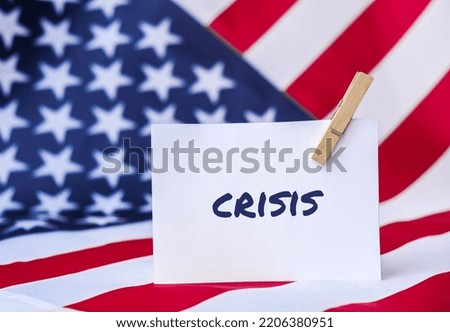 The National Flag of USA. American Flag and paper note message text CRISIS. global hunger, inflation, high prices, increasing living expenses and poverty, financial crisis, food supply issue concept