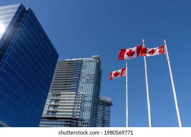 National Flags Of Canada And Vancouver City Skyscrapers Skyline In The Background. Concept Of Canadian Urban City Life.