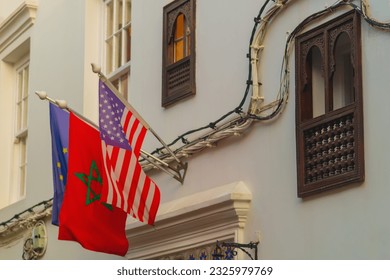 National flags of the United States and the Kingdom of Morocco and the European Union installed on a flagpole on the street of the city of Tangier in Morocco. Cooperation between governments.Celebrate - Shutterstock ID 2325979769