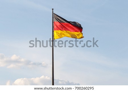 Similar – Waving German flag in front of a blue sky with clouds, Hallig Oland in the background