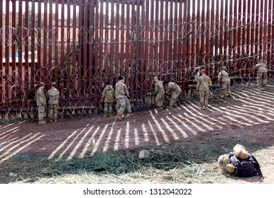 National guard troops attach razor wire to the U.S.-Mexico border wall in Nogales, Arizona on Wednesday, February 6, 2019.