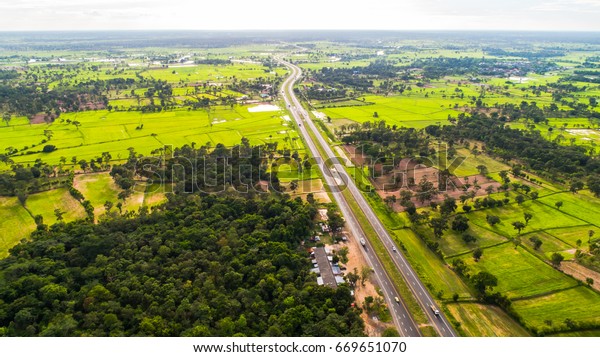 The national highway runs through the green\
fields during the farming\
season.