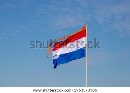 National holiday King’s Day or Koningsdag in Dutch, Due to Coronavirus disease (COVID-19) scourge, Celebrations will not take place this year, Netherlands and orange flag in the air with blue sky.