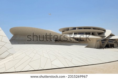 National Museum of Qatar and aircraft taking off above - Doha, Qatar