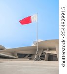 National Museum of Qatar (Desert rose) panoramic external view at blue sky with Qatar national flag.