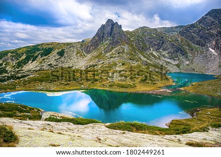 National park  Seven Rila Lakes in Bulgarian mountains.  Hiking in Bulgaria, Europe. Blue lake, purple flowers and high mount peak in summer.  Amazing scenery wallpaper for tourism. Beautiful nature.
