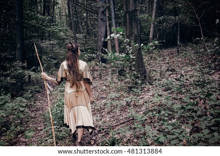 Native american beautiful girl with facepaint & spear in woods tracker healer