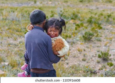 Native American Boy Holding His Little Sister Who Is Crying.