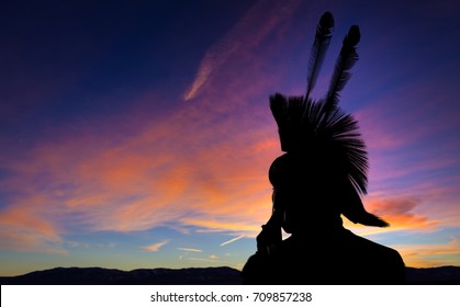 Native American Indian wearing head dress in silhouette against sunset background. - Shutterstock ID 709857238