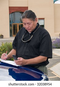 Native American Man Dialing A Number On His Cell Phone