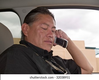 Native American Man Talking On Cell Phone In His Parked Car.