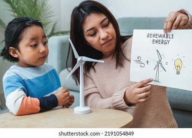 Native American Mother Working With Her Child On Renewable Energy Project For School Science Class At Home - Focus On Mom Hand