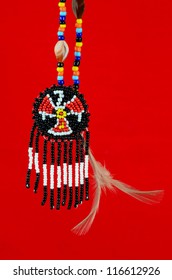 Native American Thunderbird Symbol Handcrafted Of Beads, Shells, Feathers On Red Background