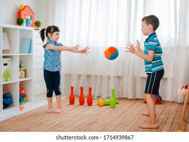 Native Children Boy And A Girl Play In A Children's Game Room, Throwing Ball. Concept Of Interaction Siblings , Communication, Mutual Play, Quarantine, Self-isolation Home, Brother Sister.