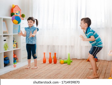 Native Children Boy And A Girl Play In A Children's Game Room, Throwing Ball. Concept Of Interaction Siblings , Communication, Mutual Play, Quarantine, Self-isolation Home, Brother Sister.