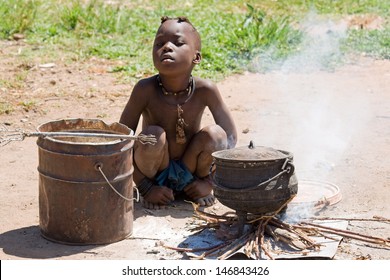 Native Himba boy cooking lunch