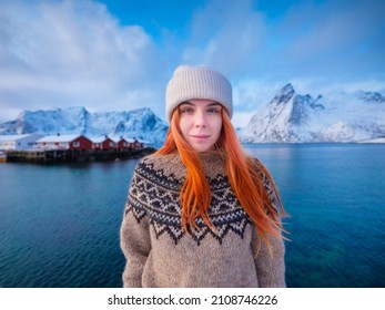Native Icelandic girl with red hair. National traditional clothing. Sweater with patterns. Portrait of a young girl. Travel and adventure.