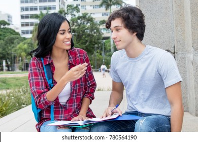 Native Latin American Female Student In Discussion With Caucasian Friend