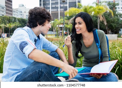 Native Latin American Student Talking With Friend Outdoors On Campus Of The University