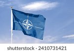 NATO flag on cloudy sky. flying in the sky