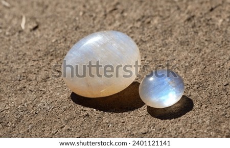 Natural adular moonstone on the sand background Imagine de stoc © 