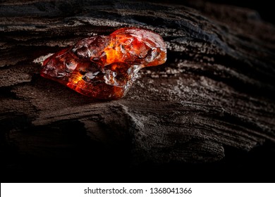 Natural Amber. A Piece Of Yellow And Red Semi Transparent Natural Amber On Piece Of Stoned Wood.