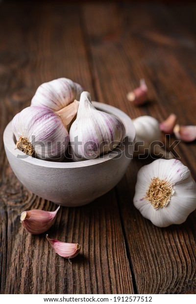 Natural antibiotic, fresh garlic bulbs with\
cloves on rustic wooden\
background
