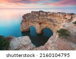 Natural arch above ocean. Natural caves at Marinha beach,  Algarve, Lagoa portugal. Stone arch at beach.
Summer season.