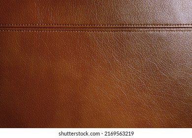 Natural, artificial brown leather texture background with decorative seam. Material for sport items, clothes, furnitre and interior design. ecological friendly leatherette.