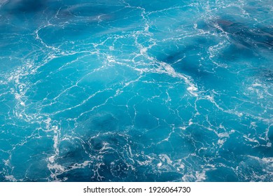 Natural background of blue foam sea water.