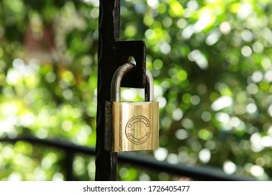 Natural Background Image Of A Padlock Hanging On The Door Iron. Lock Open And Closed.