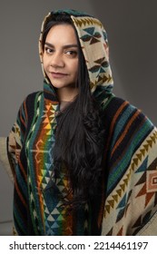 Natural Beauty And Fashion With Latin American Culture Poncho With Hood, Colorful And Warm Clothes Wearing By Young Latin Woman With Black Eyes And Hair