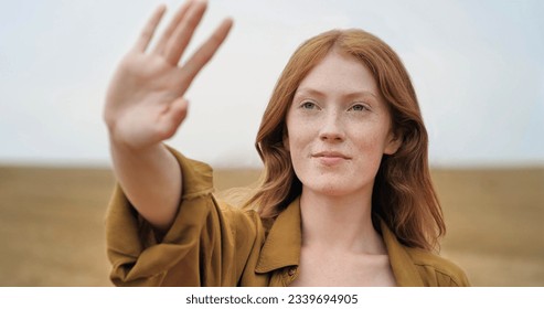 Natural Beauty Ginger Woman is standing on golden Field happily, enjoying Nature. Amazing Woman with long Red Hair, smiling Charmingly and enjoying wind blowing through her fingers. Looking Happy - Powered by Shutterstock