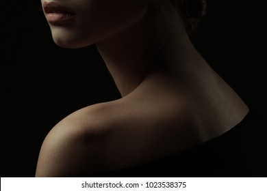 Natural beauty, purity concept. Old classic movies actress style. Close up profile portrait of gorgeous young woman with beautiful neck over black background. Studio shot
