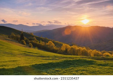 natural beauty of the rural landscape. grassy rolling hills in evening light. mountain ridge in the distance - Powered by Shutterstock