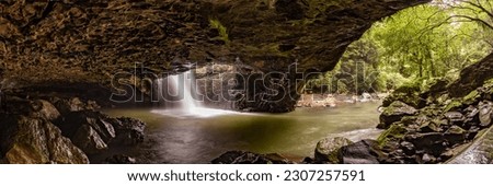 Natural Bridge Glow Worms cave in Springbrook National Park with long exposure waterfall, tourist area with scenic view in panoramic shot.