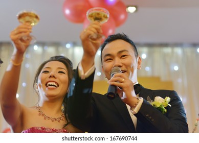 Natural Candid Photo Asian Chinese Wedding Dinner Reception, Bride And Groom Champagne Toasting.