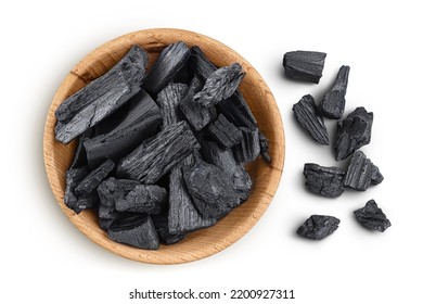 Natural charcoal in wooden bowl isolated on white background with full depth of field. Top view. Flat lay