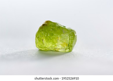Natural chrysolite, peridot, olivine apple green color transparent raw rough crystal. Earth mined untreated, unheated, ready for faceting or cabochon making. Close-up on white background.