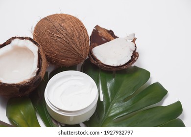 Natural coco cosmetic moisturizer cream on monstera palm leaf. SPA natural organic beauty product, skincare concept. Flat lay, top view.