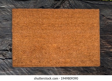 Natural Coir Doormat On Dark Wood Textured Background