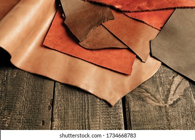 Natural color leather. Materials for leather craft. Copy space. Multi colored leather in rolls. Handmade craft. Different samples of leather on wooden table