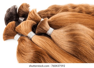 Natural colored shiny healthy human hair bundles for extension and weave wigs making. Haircare technology, style and beauty concept. Abstract texture background. Detailed closeup studio shot