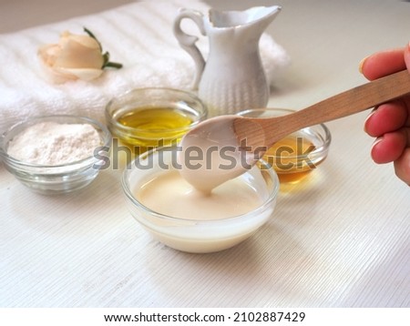 Natural cosmetics concept. Facial mask, gamage, skin scrub. Natural ingredients: rice flour, honey, olive oil, milk. Close-up of a bowl and wooden spoon