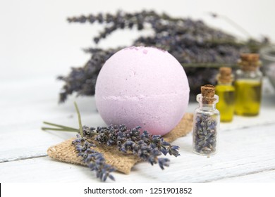 Natural cosmetics. Handmade lavender bath bombs and lavender flowers on white wooden planks, toned