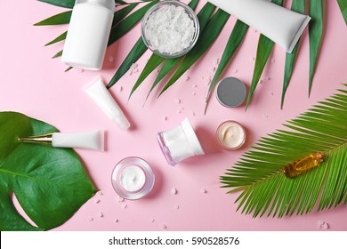 Natural cosmetics and leaves on pink background