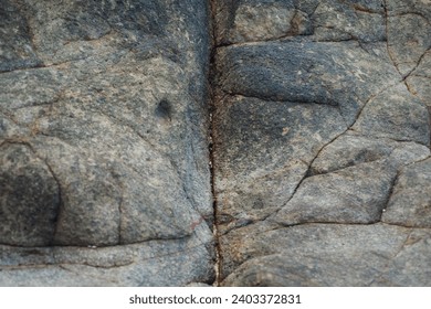 The natural cracks in the rocks along the beach form a unique pattern.