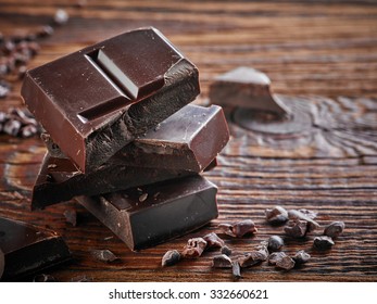 Natural Dark Chocolate Pieces On Wooden Table