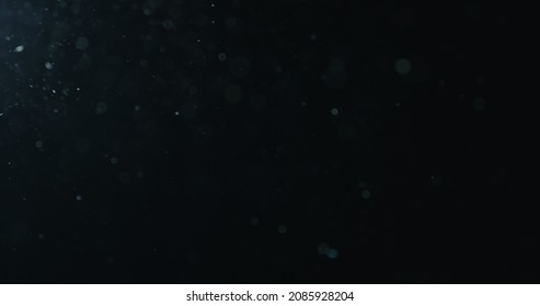 natural dust particles flow in air on black background - Shutterstock ID 2085928204