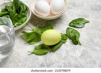 Natural dyed Easter egg and spinach leaves on grunge table